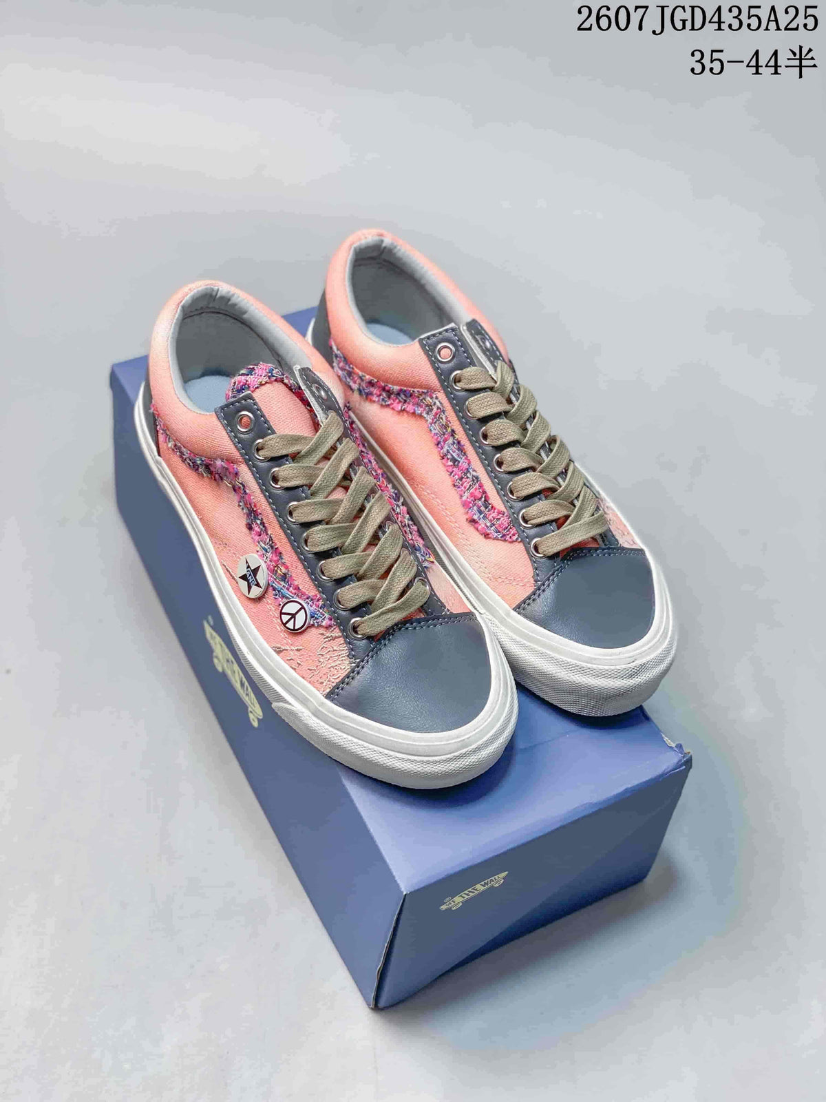 Pair of salmon pink and navy Vans sneakers displayed on a shoebox