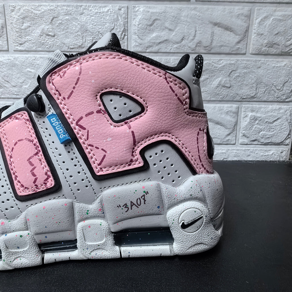 Close-up of pink heel panel, perforations, and speckled grey sole