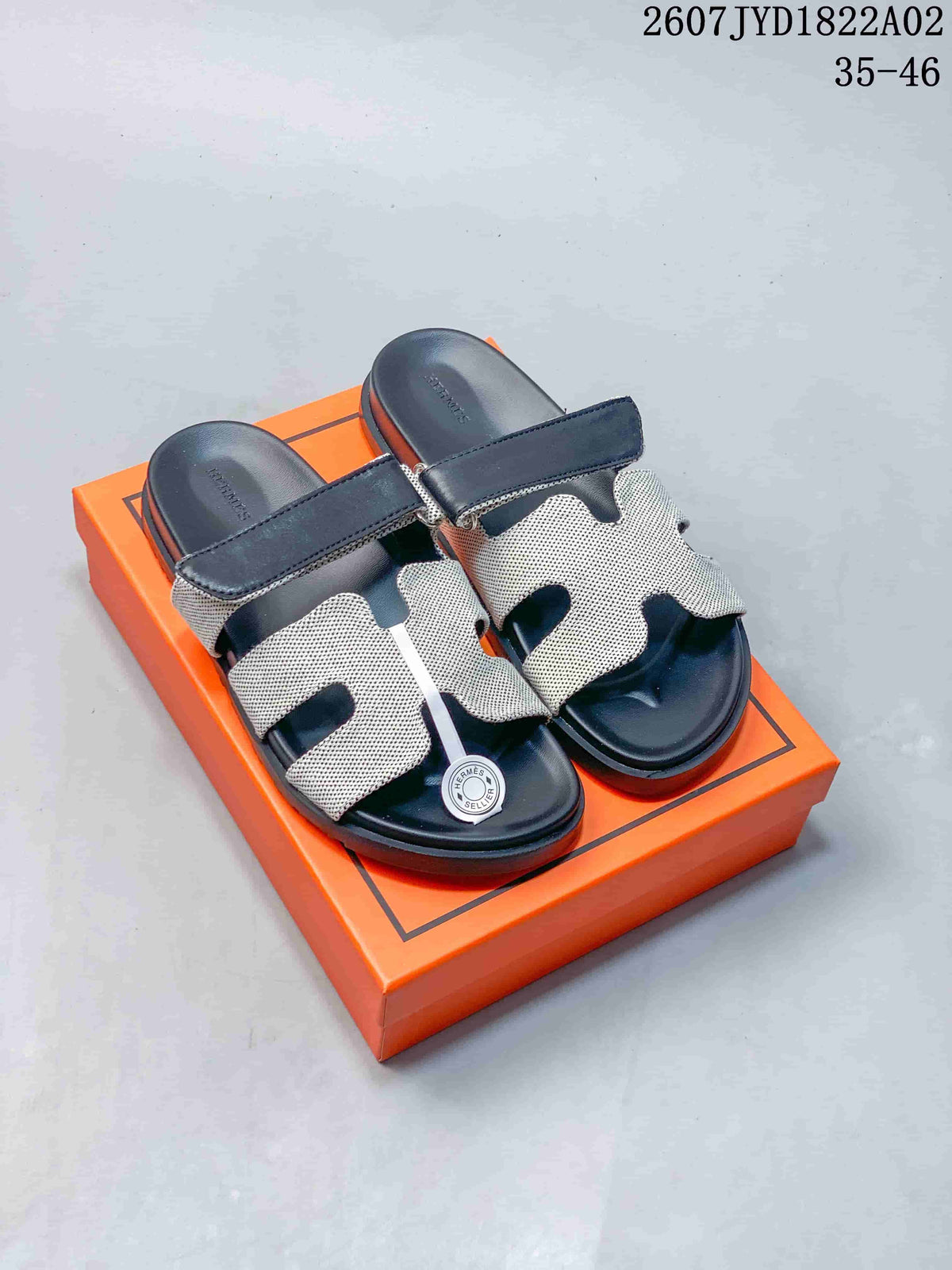 Two pairs of patterned Hermès Kazimir slide sandals shown with dark and tan strap accents.