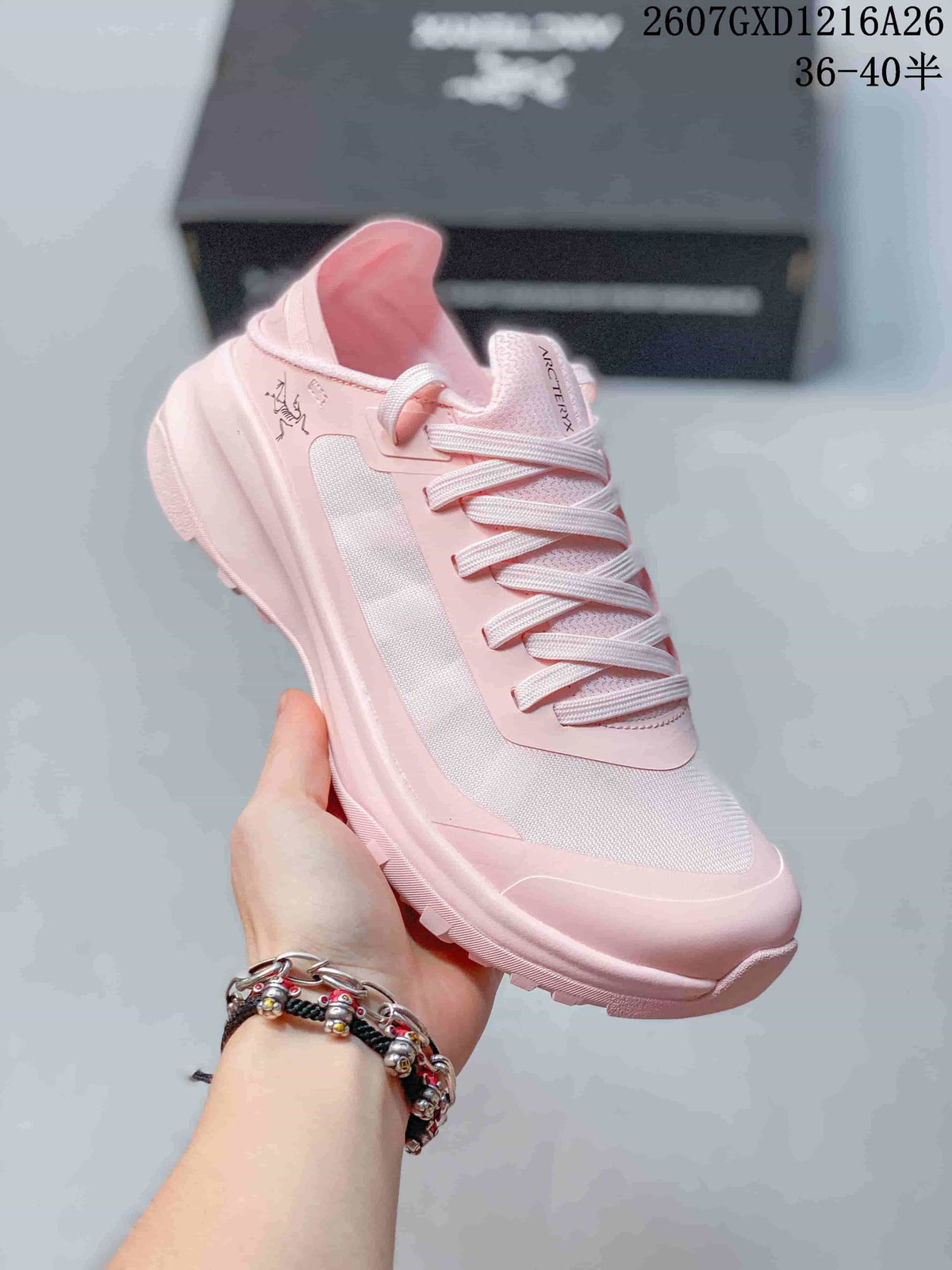Angled side view of the pink Arc'teryx Sylan shoe showing the low-top profile, lace-up design, side panel, and textured outsole.