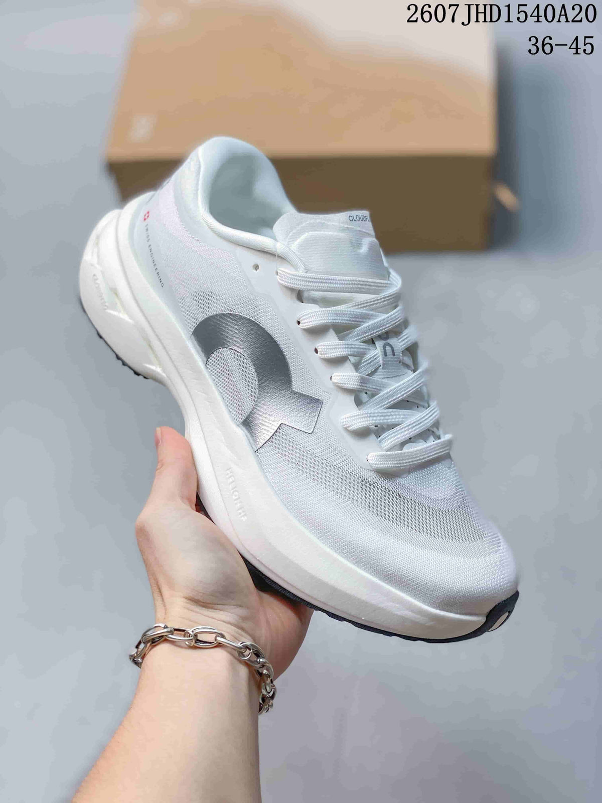 Angled side view of the white and gray sneaker showing the lace system, padded collar, side branding, and sculpted sole.