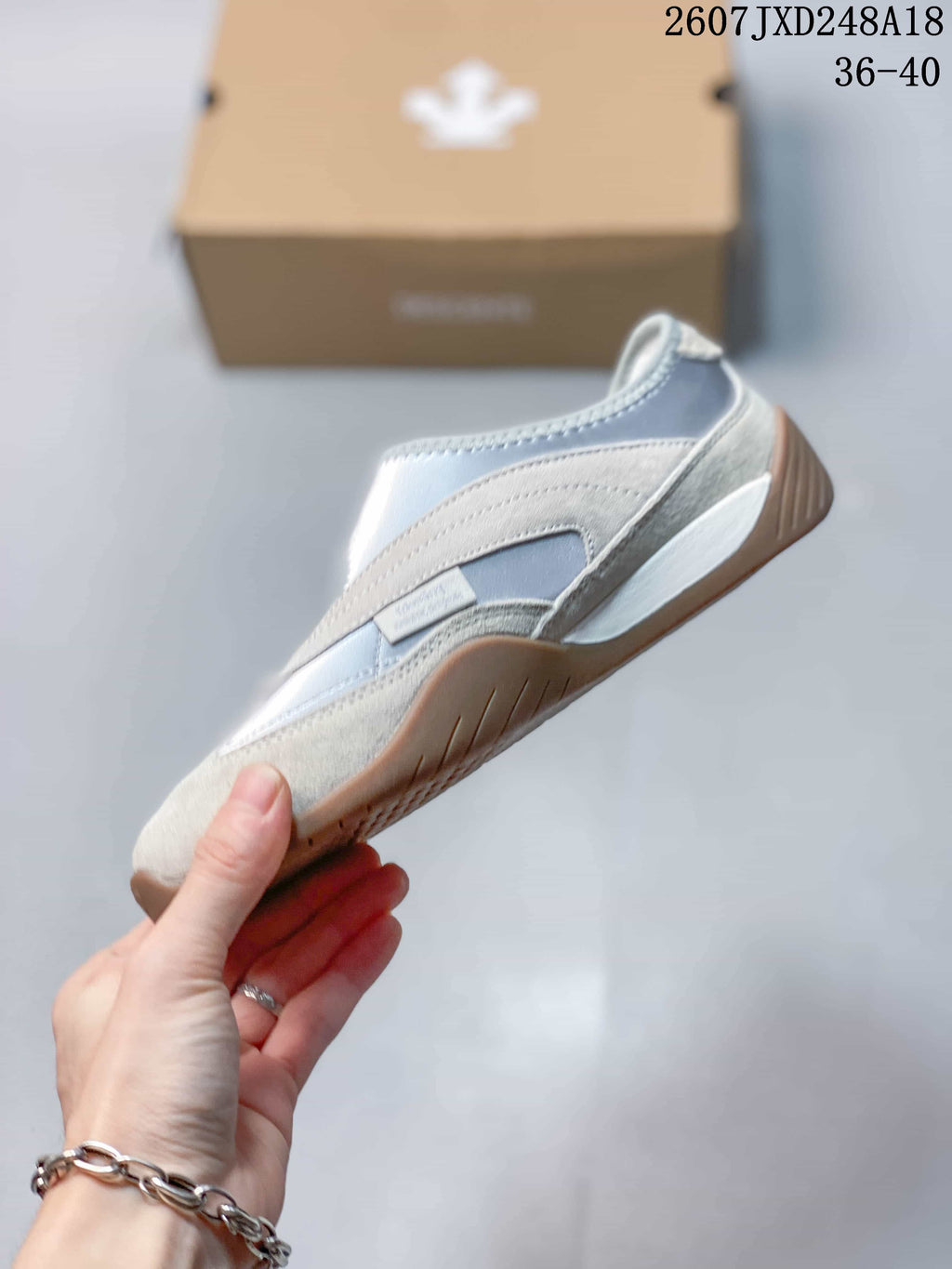 Side profile showing the layered silver and white upper and low-top shape.