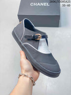 Side view of a charcoal Mary Jane flat showing its buckle strap and contrasting trim.