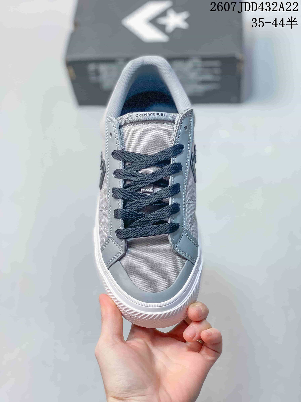 Top view of a grey Converse low-top sneaker with dark laces, textile panels, synthetic leather overlays, and a white textured sole.