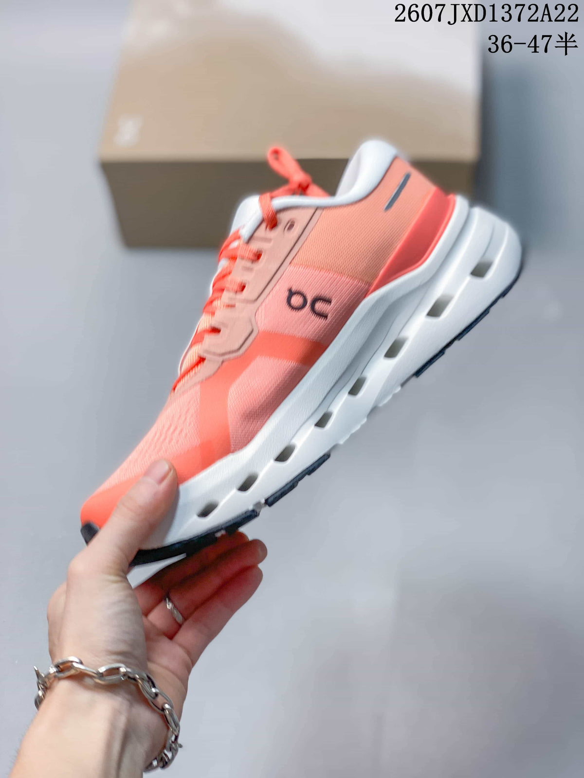Side profile of a coral On Cloudrunner 3 sneaker showing the lace system, side branding, and segmented white sole.