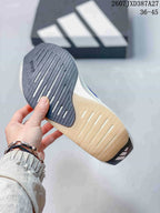 Bottom view of the sneaker showing a dark forefoot outsole section and a light-colored outsole with linear grooves.