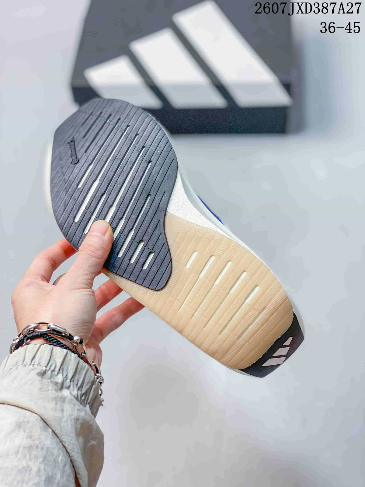 Bottom view of the sneaker showing a dark forefoot outsole section and a light-colored outsole with linear grooves.