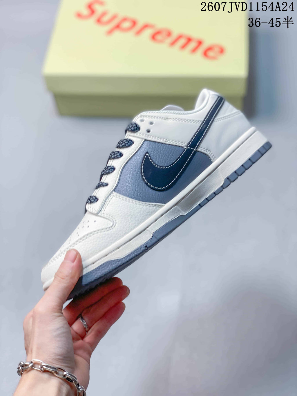 Side view showing the white upper, gray panel, navy Swoosh detail and layered sole.