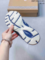 Underside of a white and navy sneaker showing segmented outsole tread
