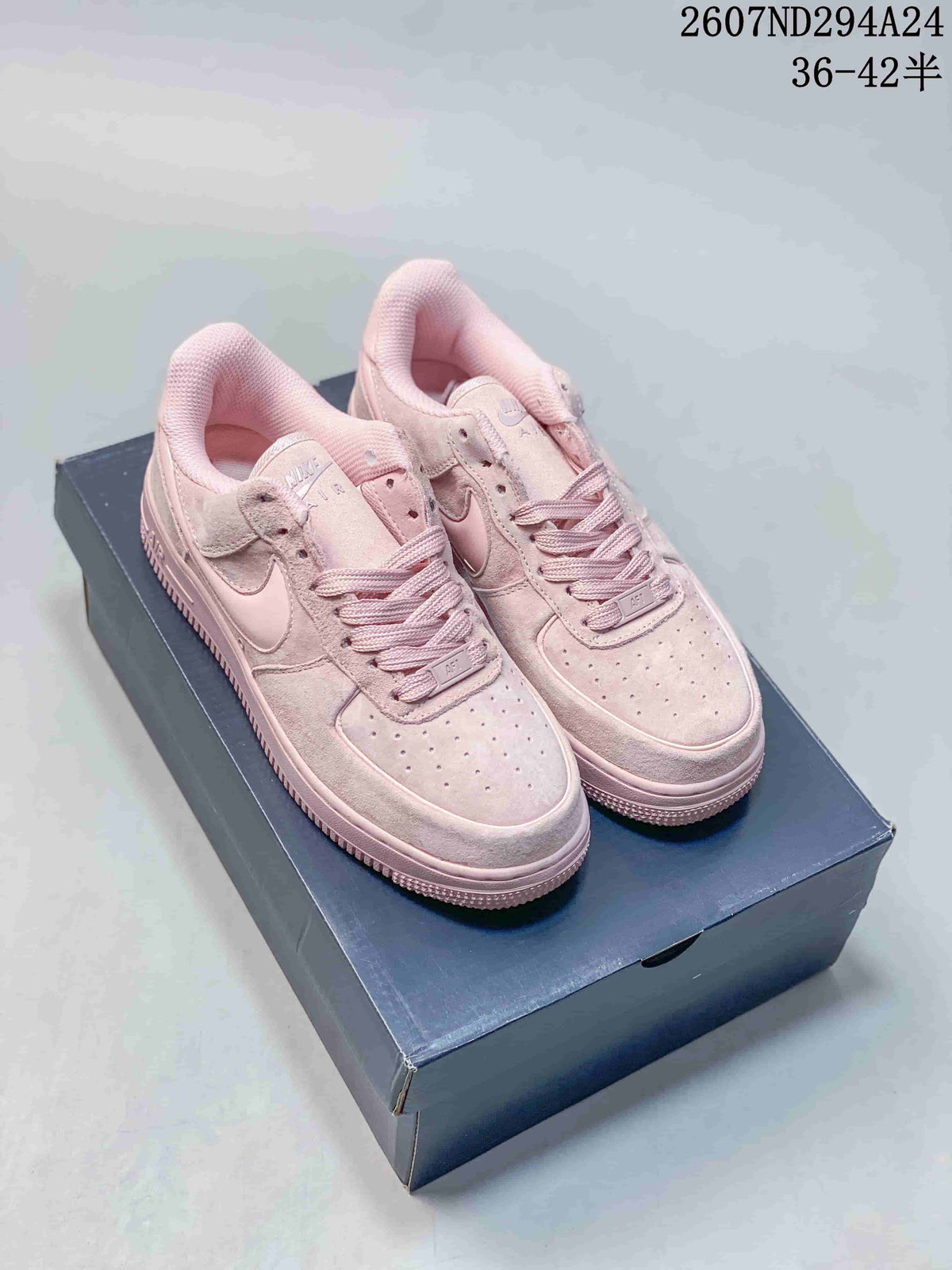 Pair of soft pink Nike Air Force 1 '07 low-top sneakers displayed on a shoebox.