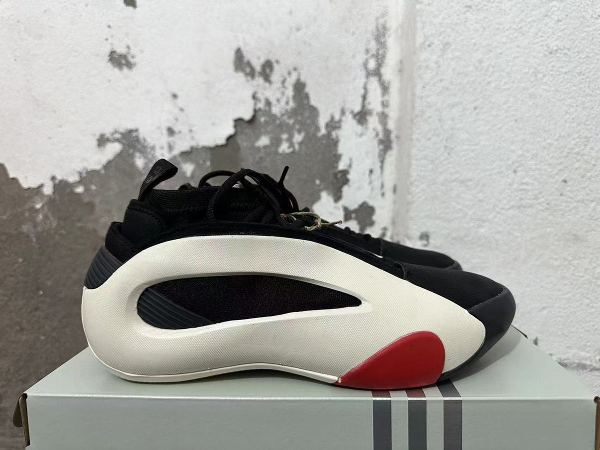 Side view showing sculpted white panels and a red accent on the black sneaker