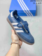Side view of a blue Samba Jane sneaker showing the strap, three stripes, and gum-colored outsole.