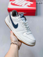 Angled side view highlighting the white upper, navy side detailing, padded collar and gum outsole.