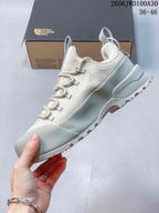 Side view of a light gray and off-white low-top outdoor shoe
