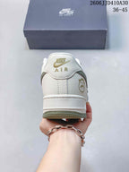 Rear view of the white sneaker with gold-toned heel branding and green outsole