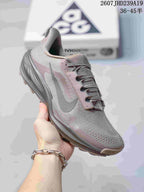 Close side view of a mauve-gray Nike ACG Pegasus Trail sneaker with a textured upper and contrasting sole.