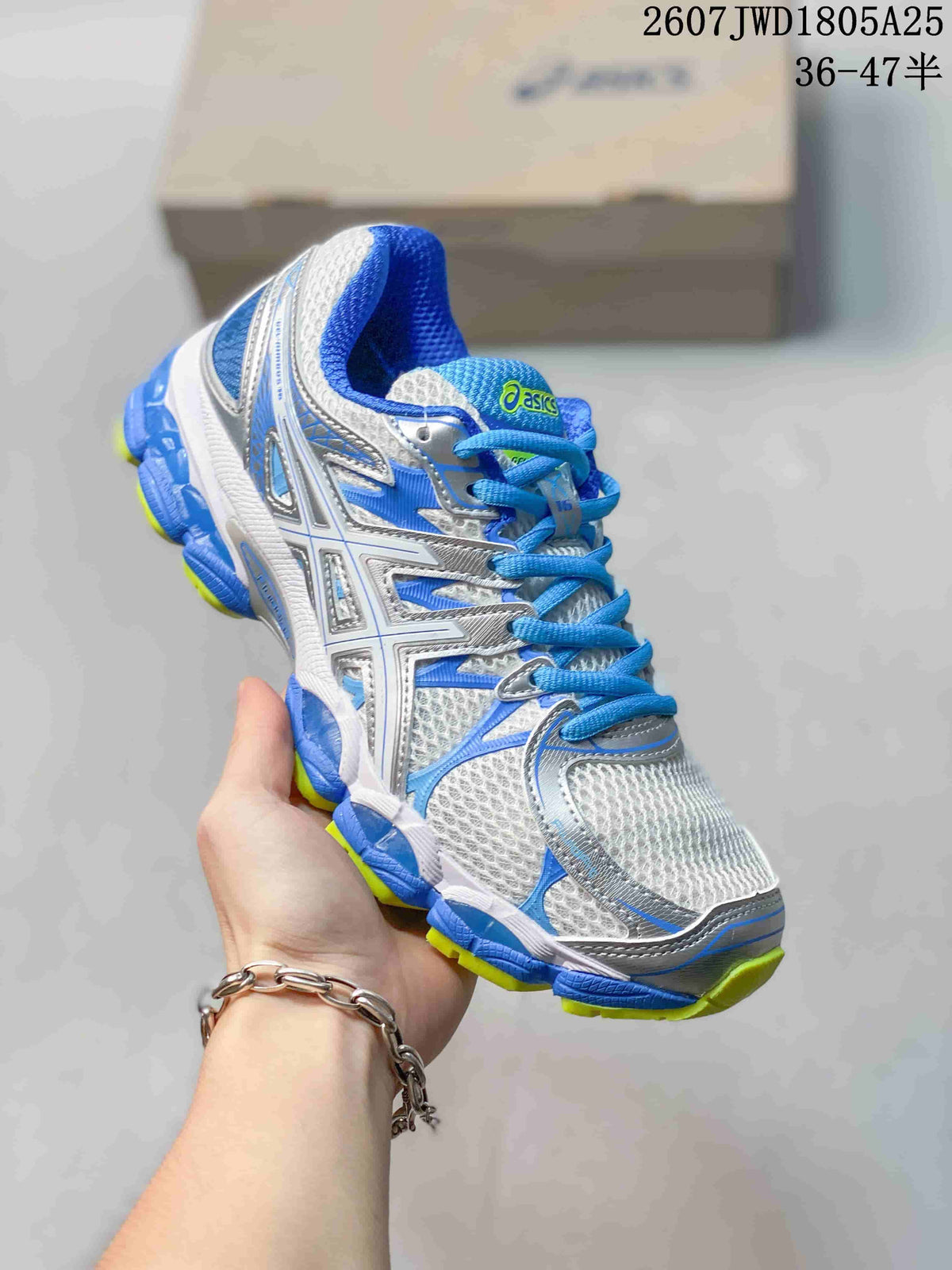 Angled close-up of the ASICS sneaker showing the side branding, mesh-look upper, blue accents, and neon yellow outsole.