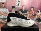 Side profile of a black basketball shoe with a textured white side panel and sculpted sole