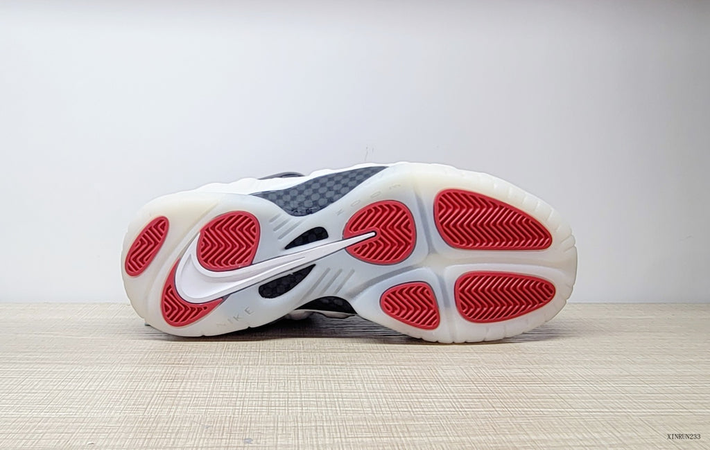 Outsole view of Nike Air Foamposite One sneakers with red traction sections