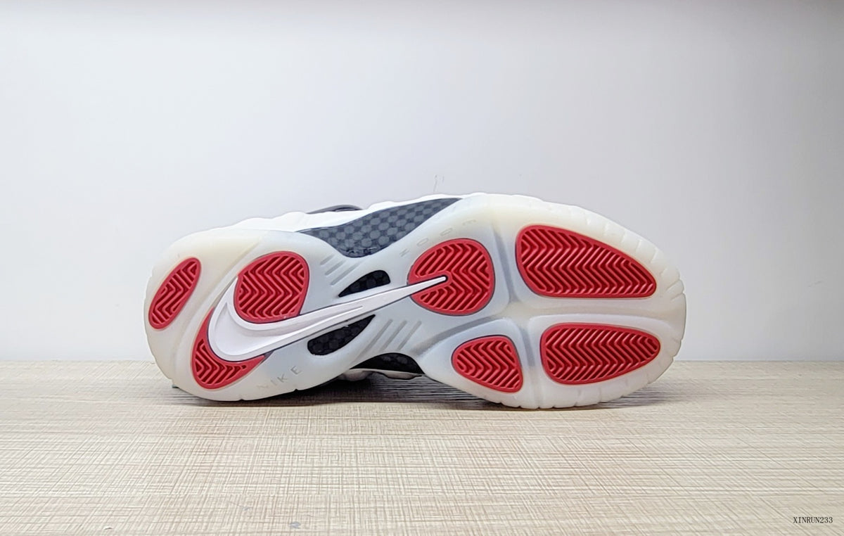 Outsole view of Nike Air Foamposite One sneakers with red traction sections