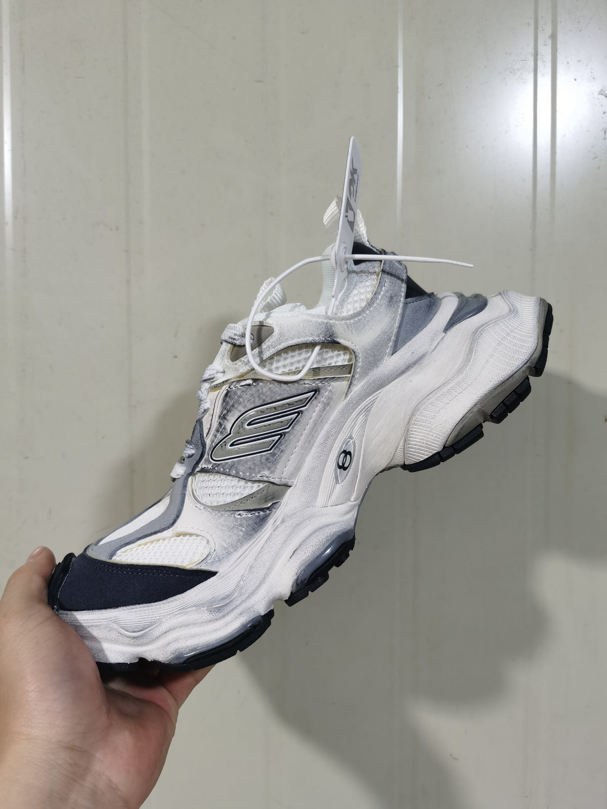 Side view of the white and grey Balenciaga cargo sneaker showing the contrasting dark toe, layered upper, and sculpted outsole.