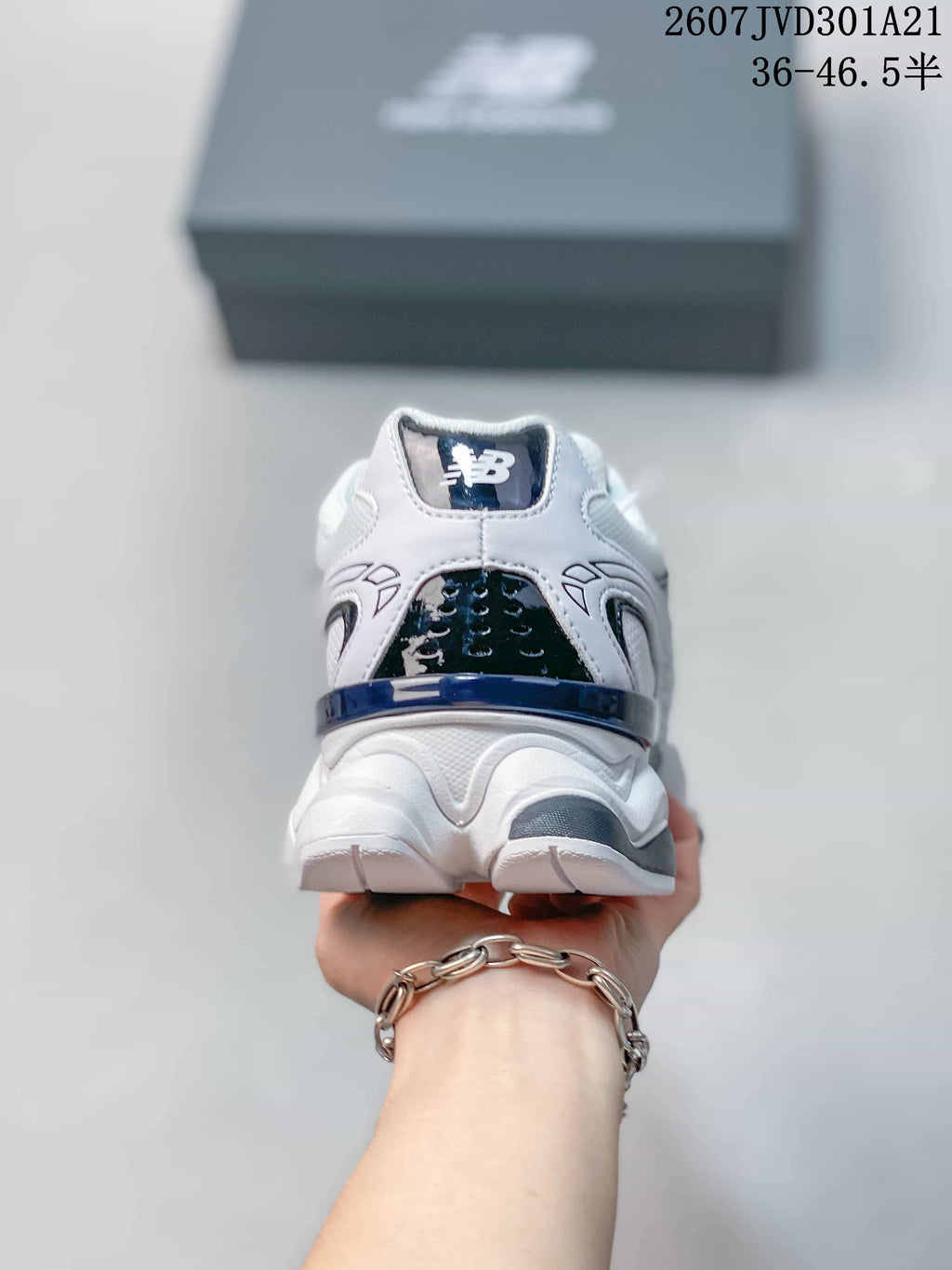 Rear view of the white, navy, and black New Balance 9060R sneaker with the New Balance logo on the heel.