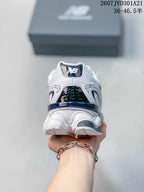 Rear view of the white, navy, and black New Balance 9060R sneaker with the New Balance logo on the heel.
