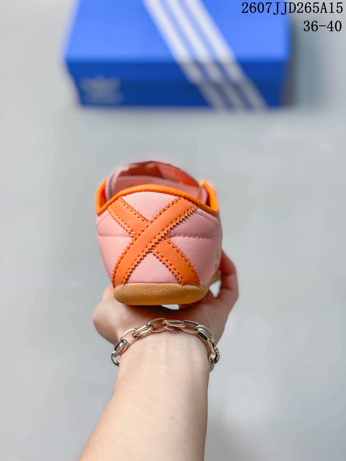 Rear view showing the pink heel, orange crossed detail, and gum-colored outsole.