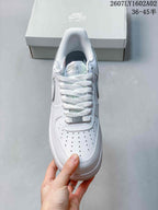 Top view of a white low-top sneaker with perforated toe and laces