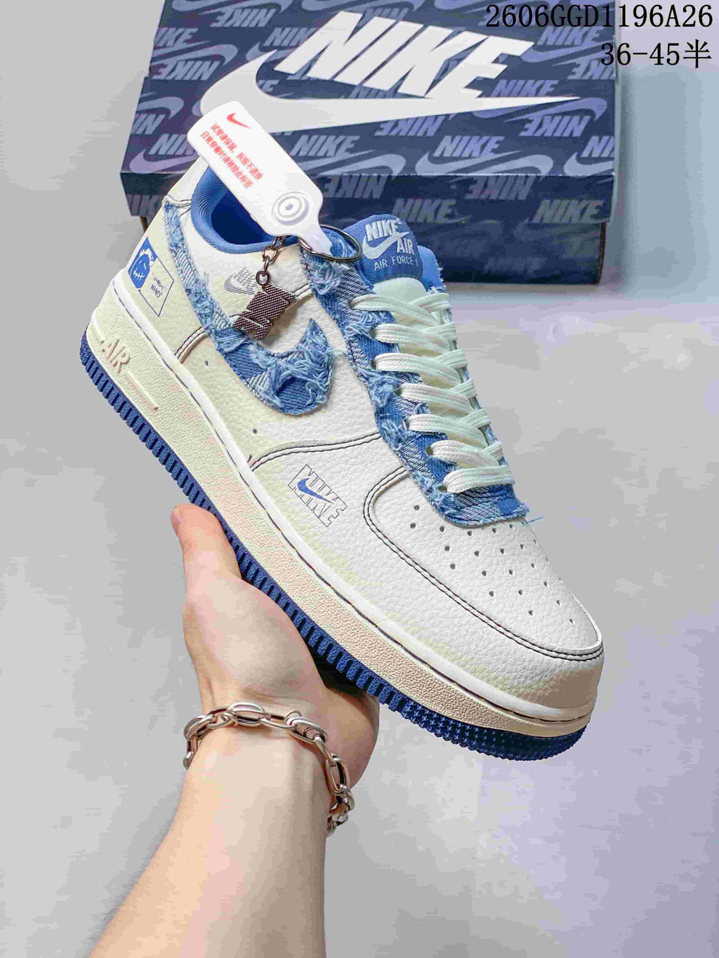 Close-up of a white sneaker with a frayed blue denim-look Swoosh and blue outsole.