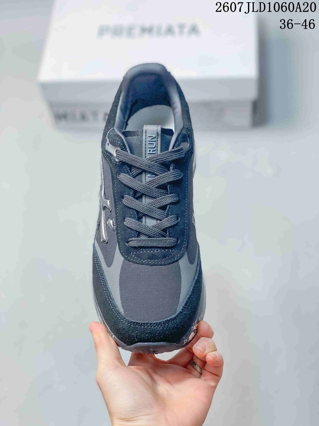 Top view of a black and gray lace-up trainer showing the tongue, eyelets, laces, and tonal panel construction.