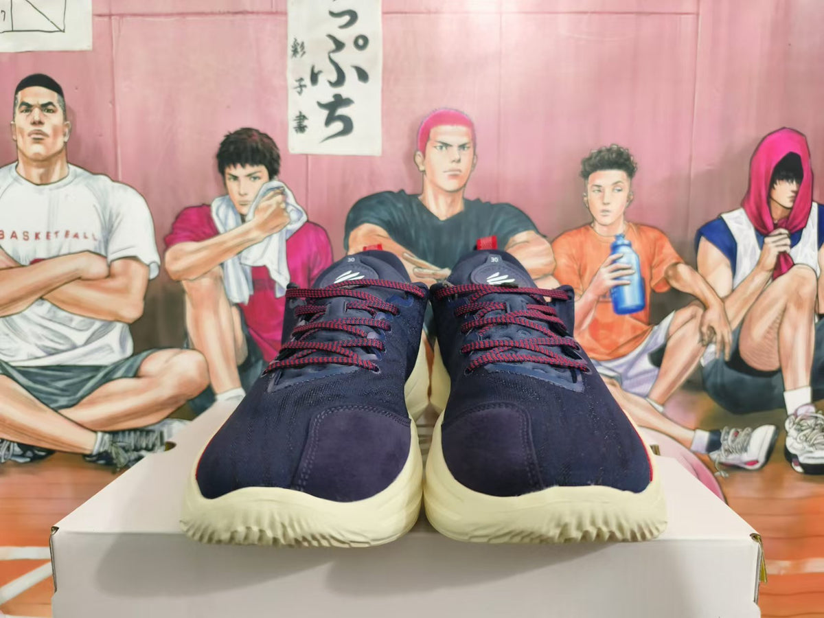 Front view of navy low-top basketball shoes with red laces and pale cream-colored soles