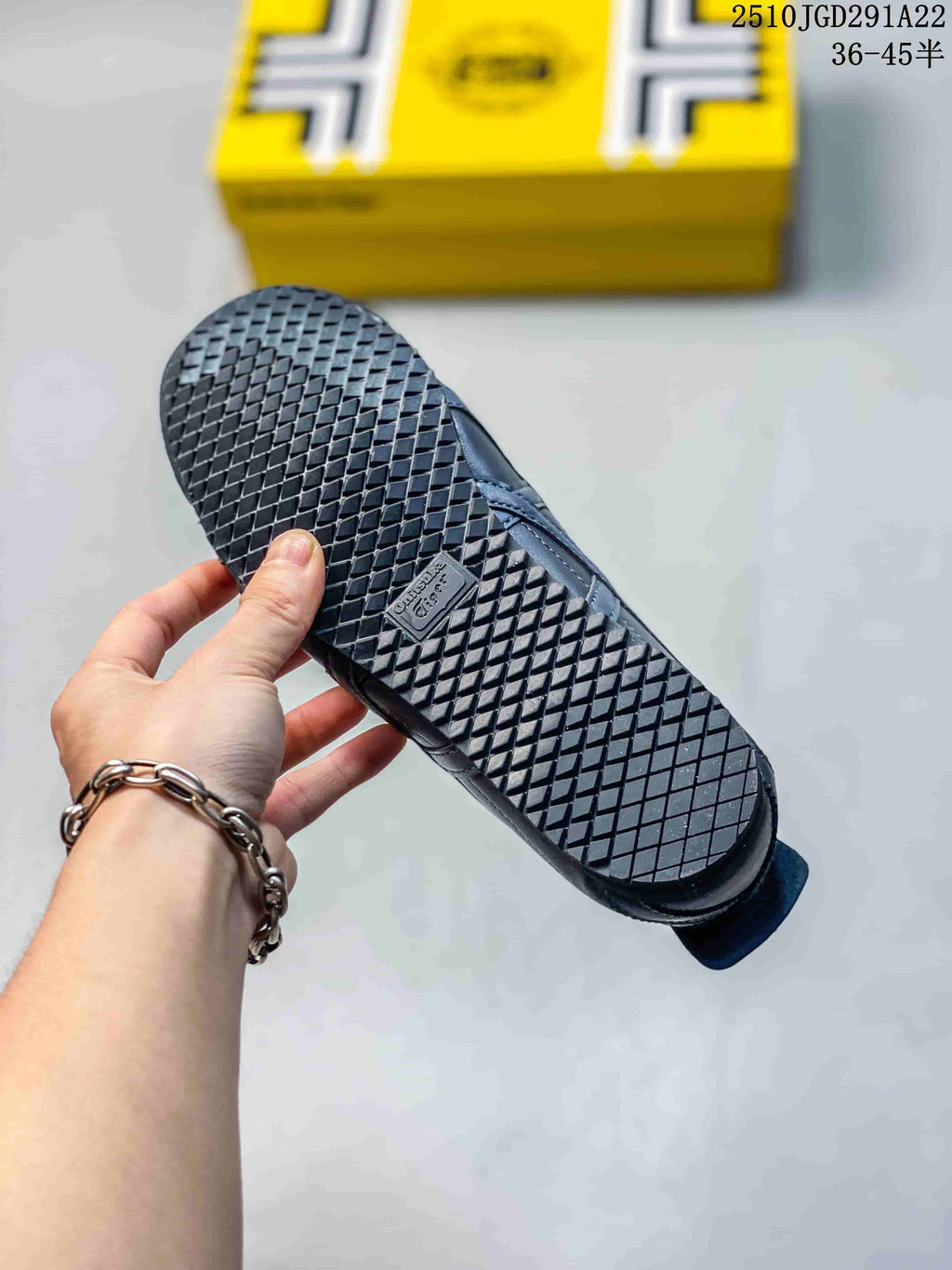 Bottom view of a black sneaker showing the patterned rubber outsole and tread.
