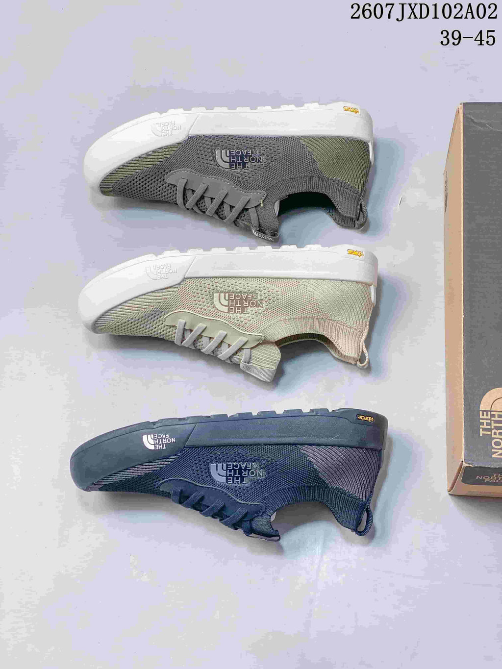 Pair of light sage The North Face Dune sneakers with knit-look uppers displayed on a shoe box.