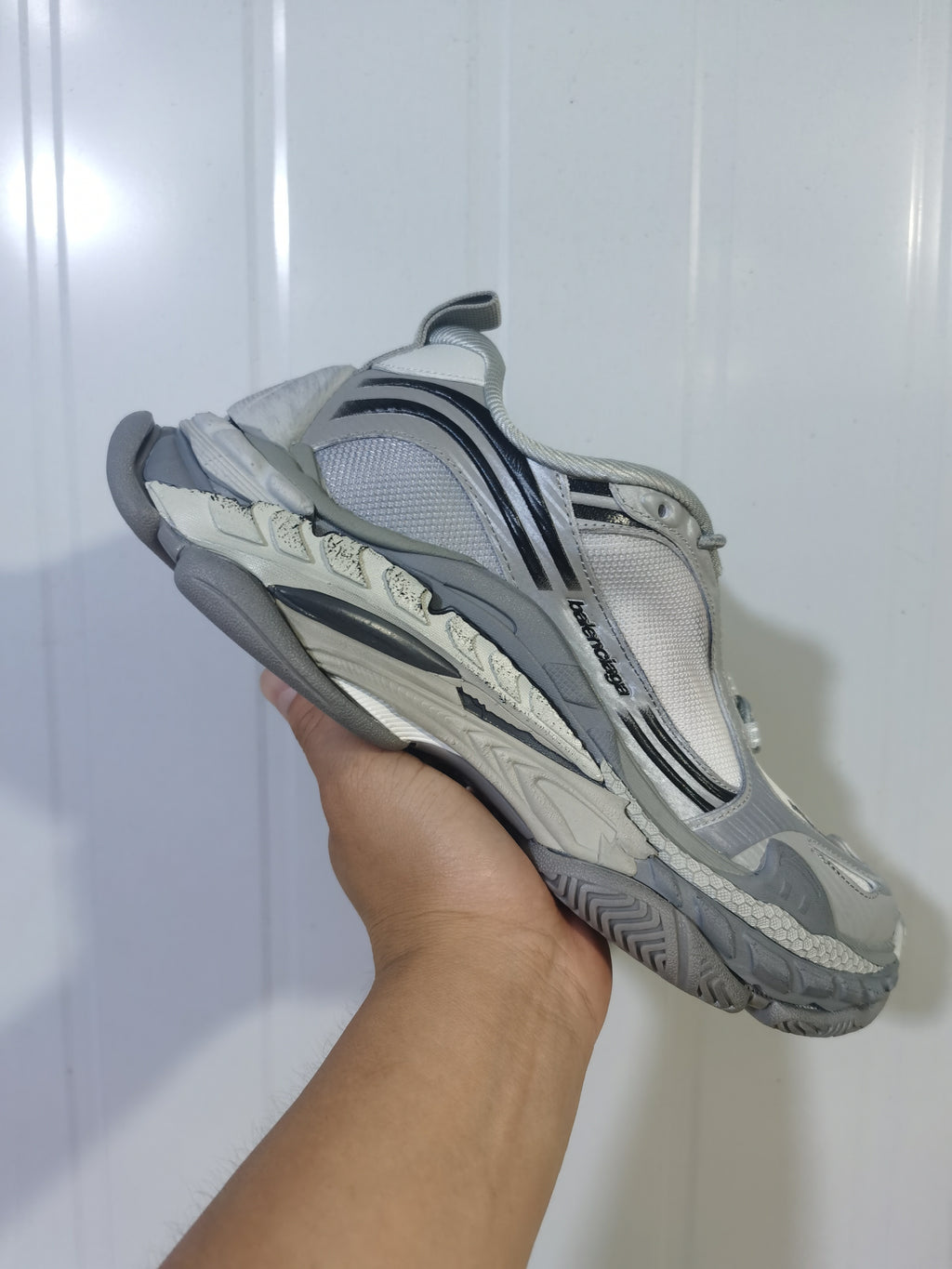 Angled underside view of the gradient grey sneakers showing the layered sole, mesh upper, and side branding.