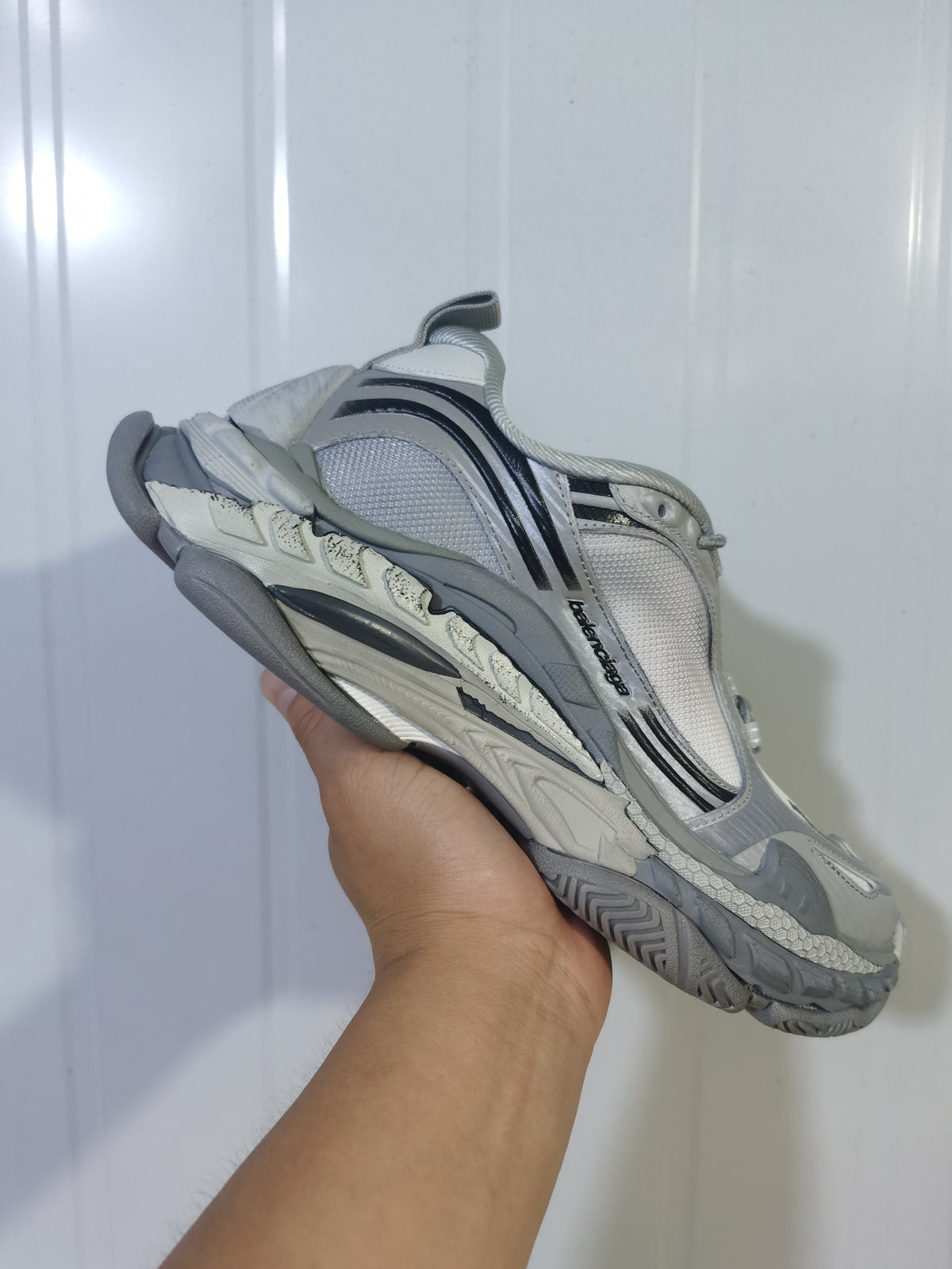 Angled underside view of the gradient grey sneakers showing the layered sole, mesh upper, and side branding.