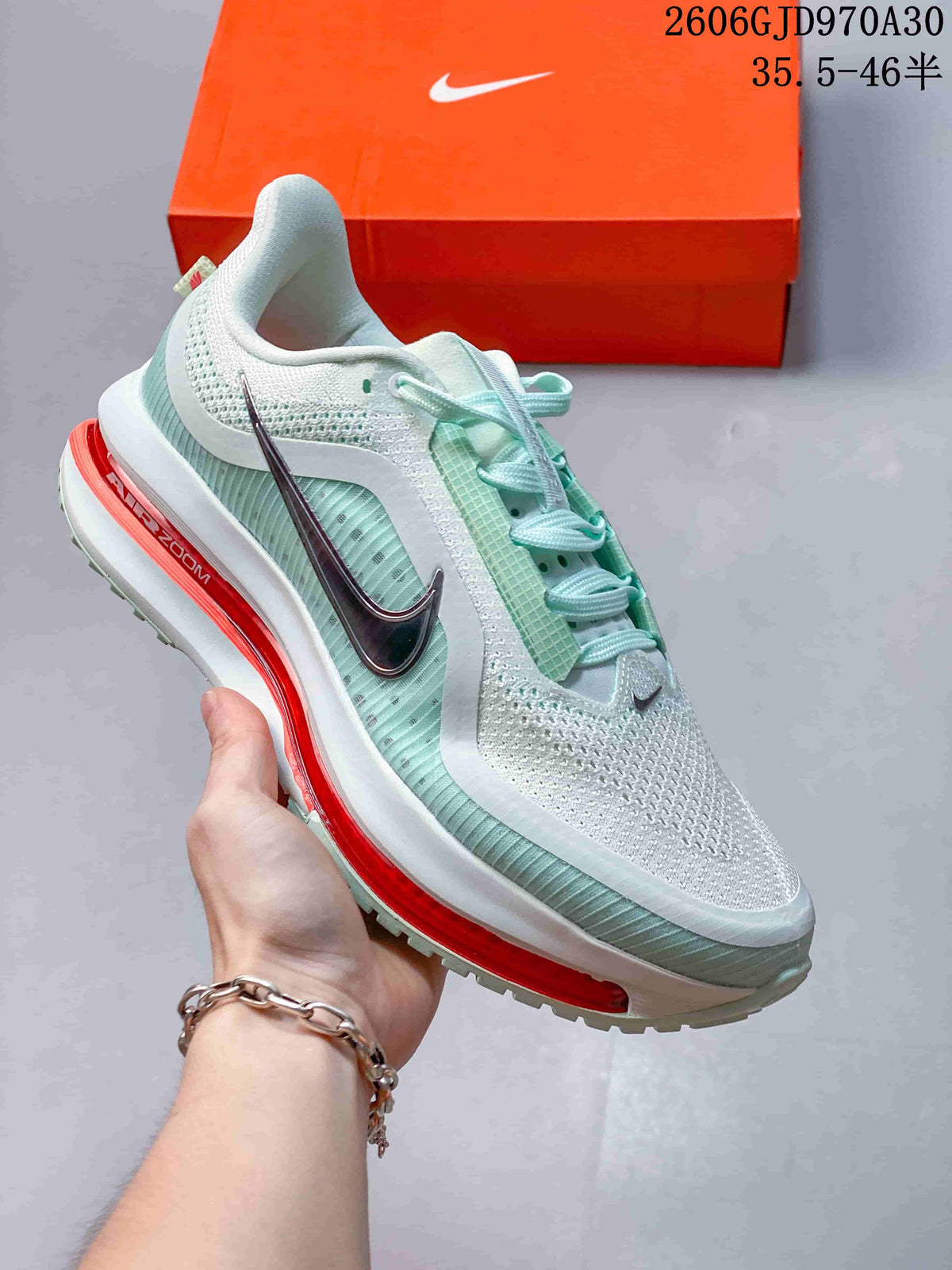 White and mint Nike Air Zoom Pegasus Premium sneaker with dark metallic side Swoosh and red-orange midsole accent.