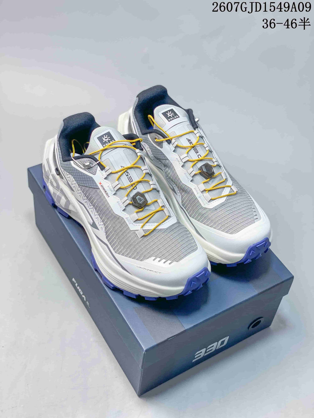 Pair of Kailas Fuga Ex 330 shoes in grey and white with purple outsoles and yellow laces, displayed on a 330-branded box.