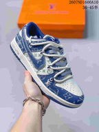 Angled side view showing the blue and white sneaker, patterned panels, branded side details, and white midsole.