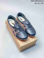 Pair of navy and brown Versace x Onitsuka Tiger sneakers displayed on a branded shoebox; style code and size range are overlaid above.