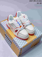 Pair of white and red Louis Vuitton Trainer low-top sneakers on a patterned box