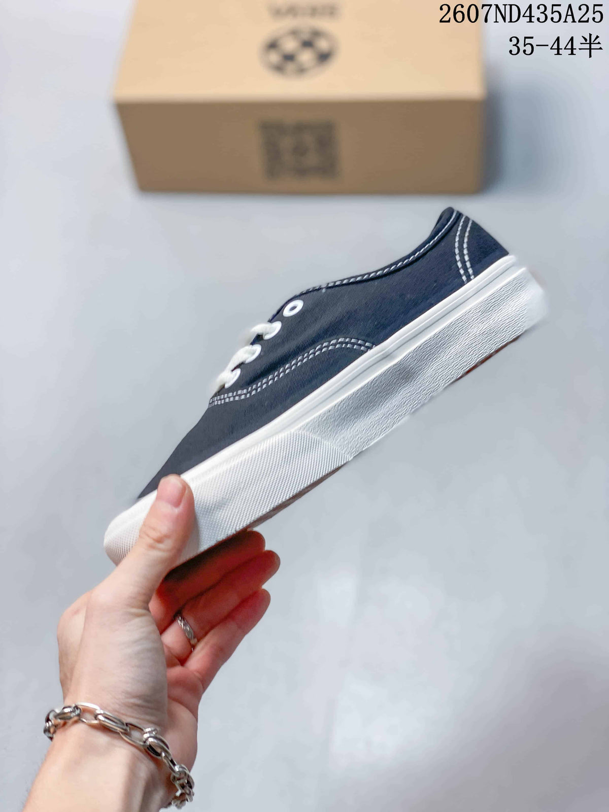 Side profile of the navy low-top sneaker showing contrast stitching and a white rubber sidewall.