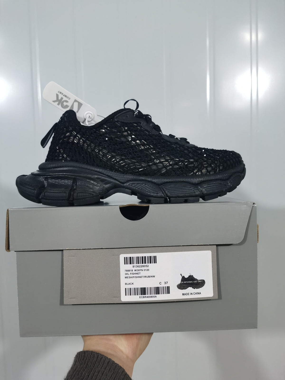 Black sneaker displayed on its box; the label shows 3XL FISHNET, BLACK, and a photographed size of C 37.