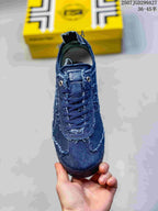 Front view of the blue sneaker showing the laces, eyelets, tongue and stitched toe area.