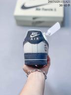 Rear view of the white and navy sneaker showing the padded collar, heel branding, and layered rubber sole.