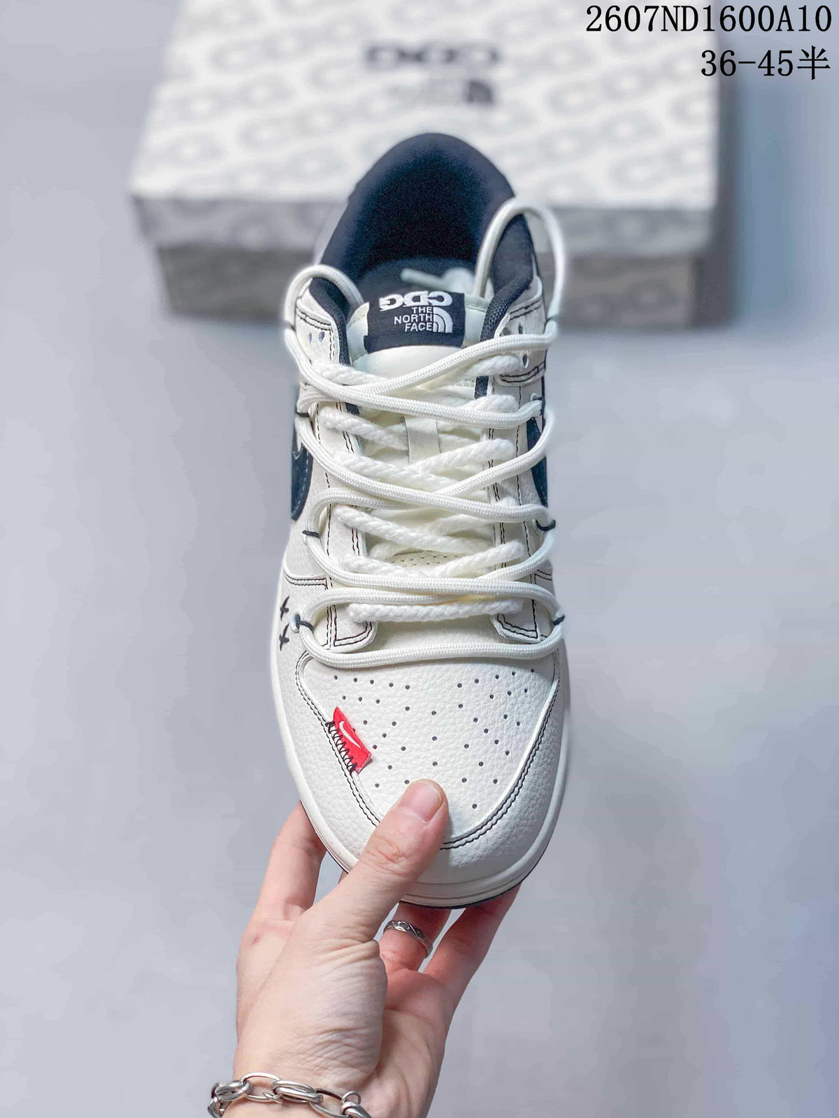 Top view showing white laces, perforated toe box, navy tongue lining and red toe detail.