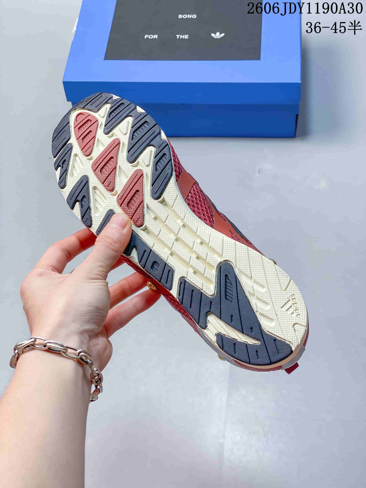 Close-up of the multicolor outsole with cream, rose, and dark tread sections.