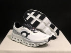 White and black On Cloudmonster 2 shoes showing the outsole and side profile