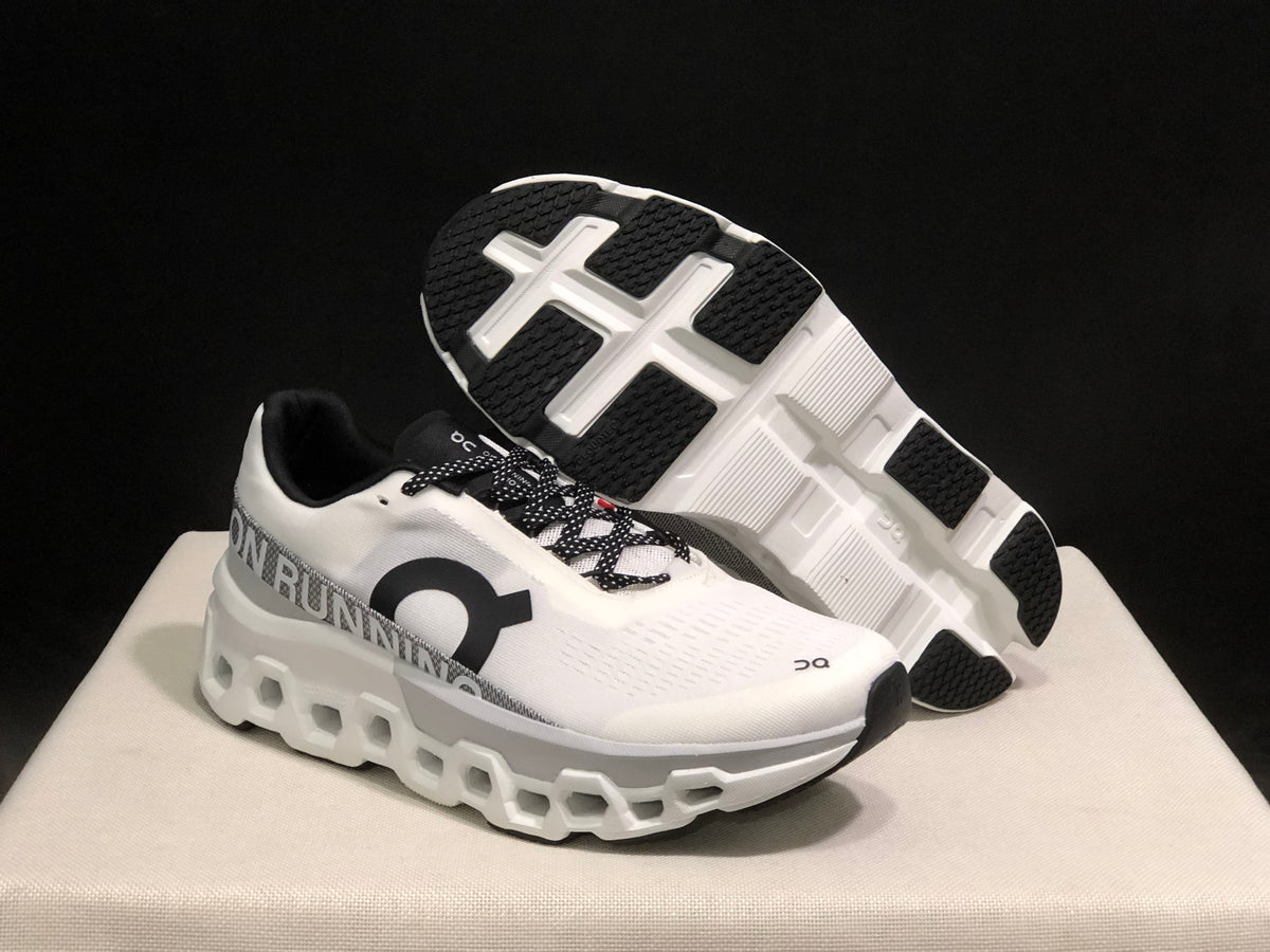 White and black On Cloudmonster 2 shoes showing the outsole and side profile