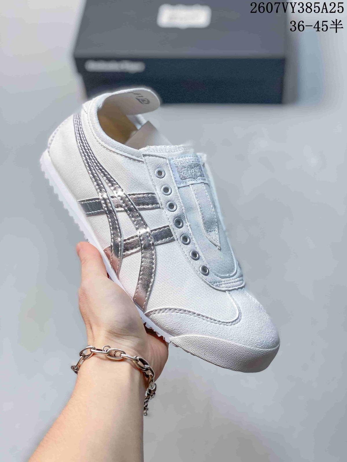 White slip-on sneaker with metallic silver side stripes and a light outsole.
